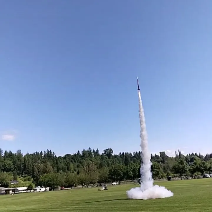 A rocket climbing on a column of white smoke